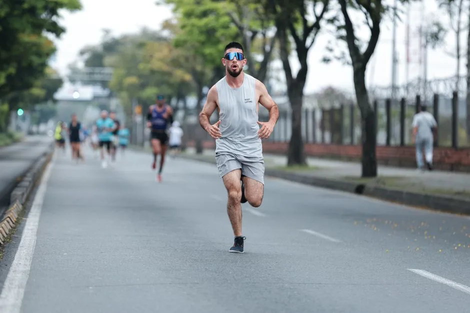 Coureur en pleine foulée sur une route goudronnée